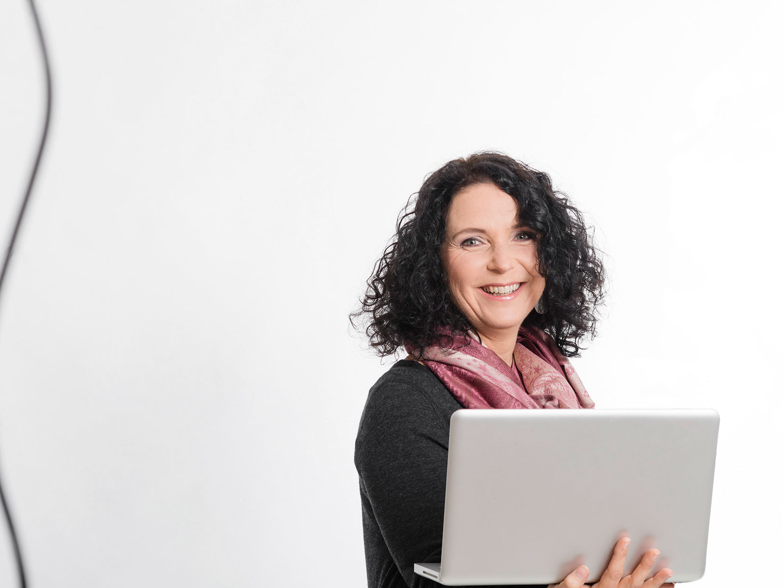 Ruth Langer auf der roten Couch mit Laptop